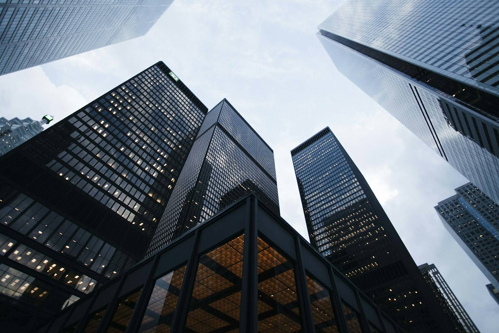 Glass and steel office towers viewed from street level against a pale sky